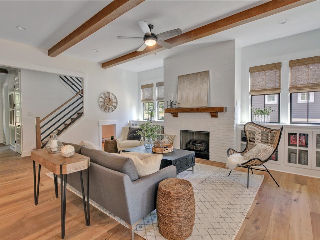 Living room with white brick fireplace and wood beams