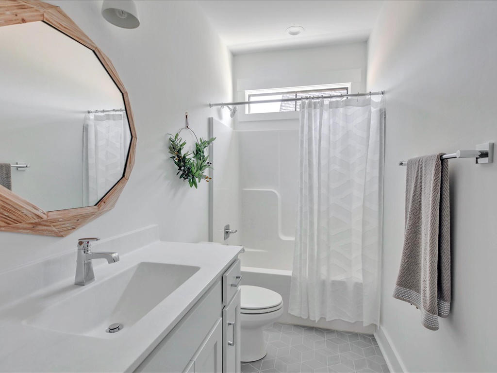 Hall bath with round wood mirror