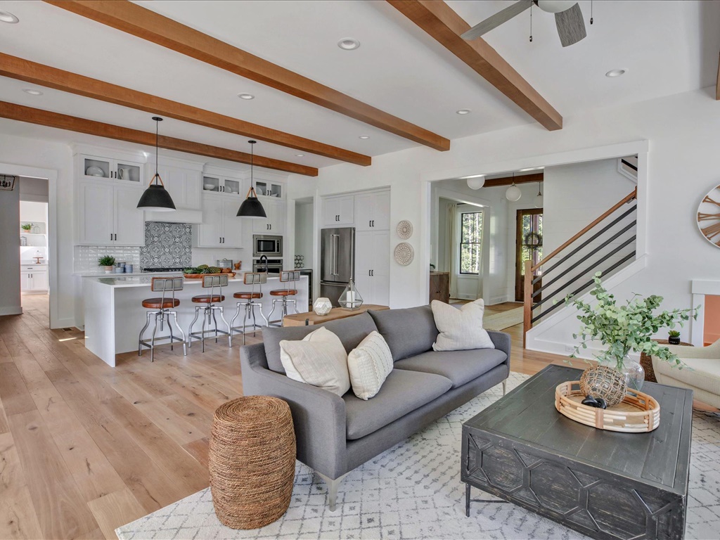 Great room open to chef's kitchen with exposed wood beams